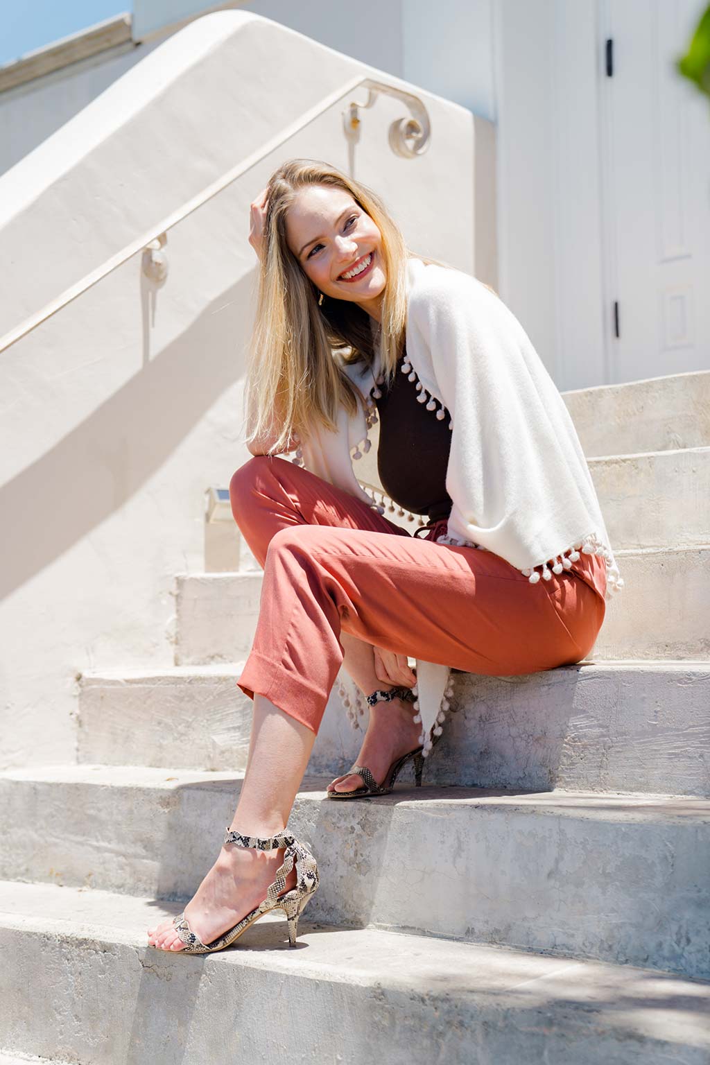 Model Wearing Alpine Cashmere Pom-Pom Triangle Wrap in Ivory