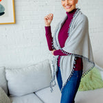 Model Wearing Alpine Cashmere Pom-Pom Triangle Wrap in Birch and Flannel Gray