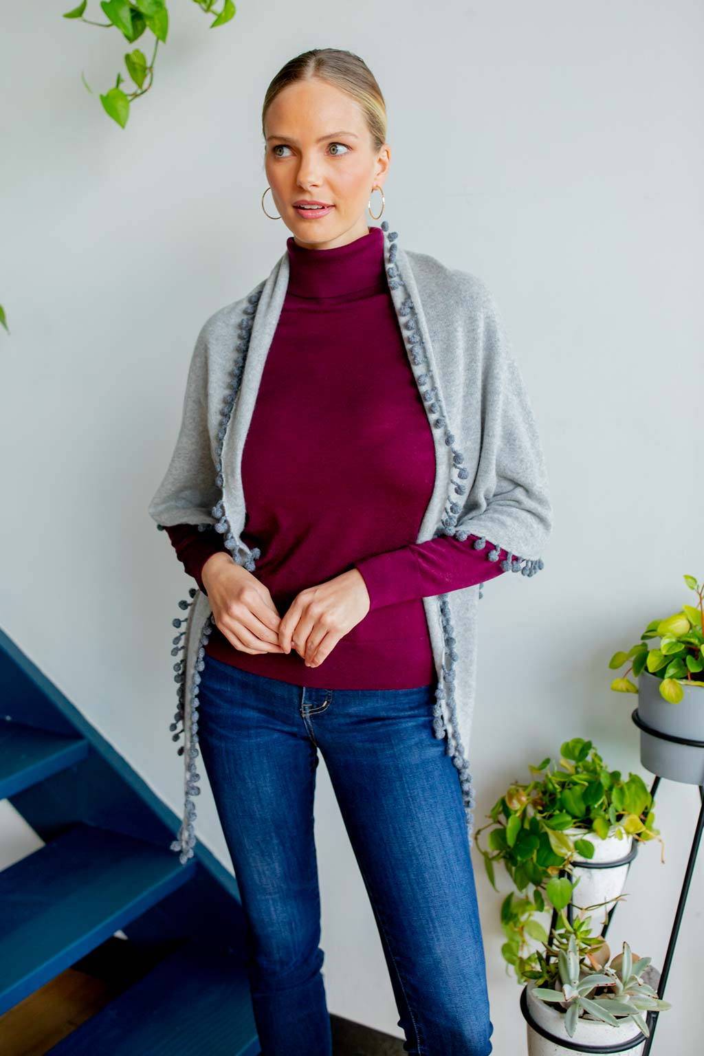 Model Wearing Alpine Cashmere Pom-Pom Triangle Wrap in Birch and Flannel Gray