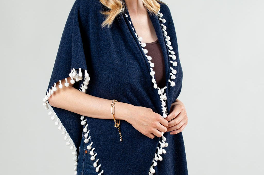 Model Wearing Alpine Cashmere Pom-Pom Triangle Wrap in Midnight Blue and Ivory