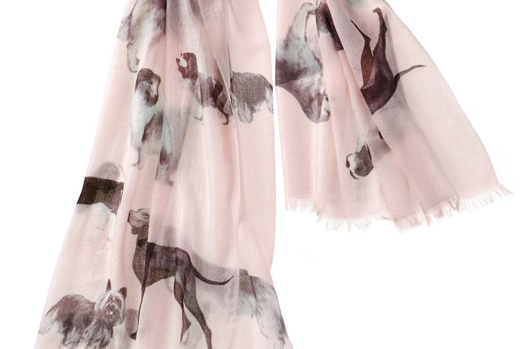 Alpine Cashmere's Dog's Life Scarf, featuring an illustrated print of dogs, in blossom pink