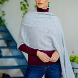 Model Wearing the Alpine Cashmere Herringbone Travel Wrap in Birch Gray and Ivory