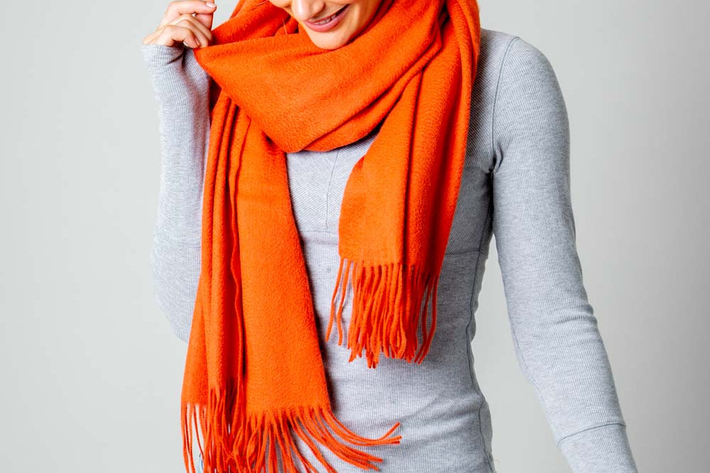 Model Wearing Alpine Cashmere Ripple Finish Wrap in Persimmon Orange