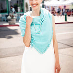 Model Wearing Alpine Cashmere Pom-Pom Triangle Wrap in Aquamarine