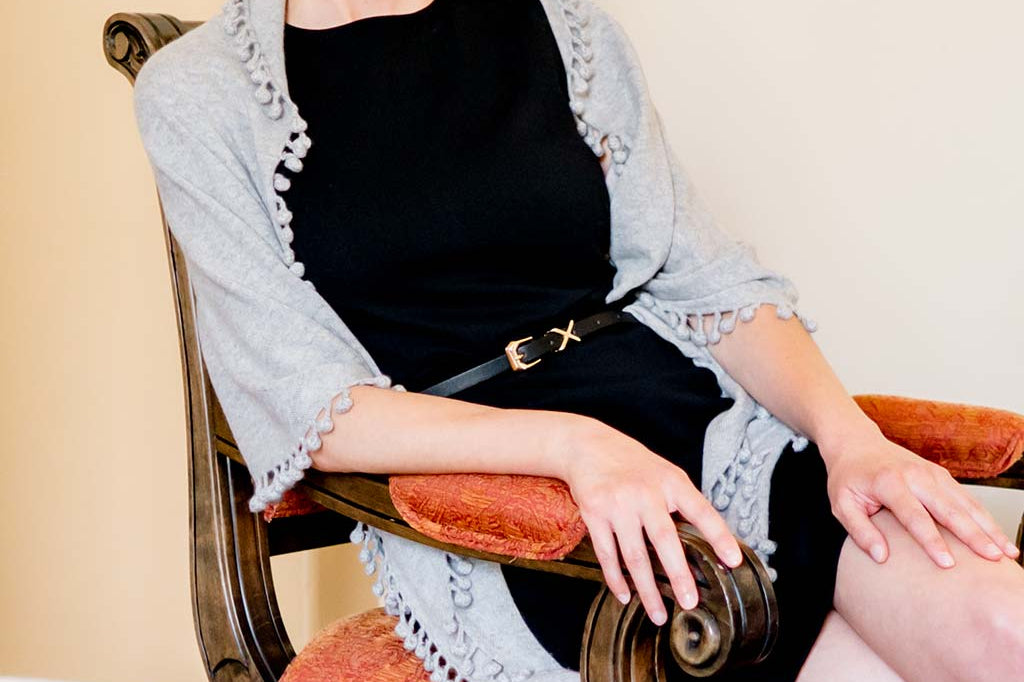 Model Wearing Alpine Cashmere Pom-Pom Triangle Wrap in Birch Gray