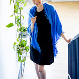 Model Wearing Alpine Cashmere Pom-Pom Triangle Wrap in Cornflower Blue