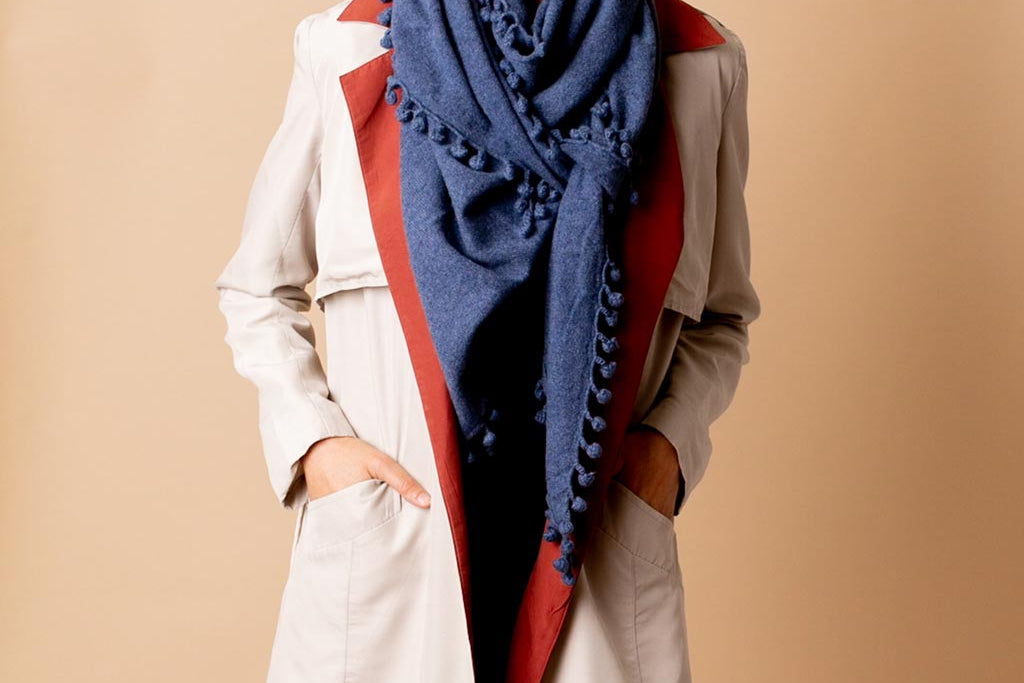 Model Wearing Alpine Cashmere Pom-Pom Triangle Wrap in Denim Blue