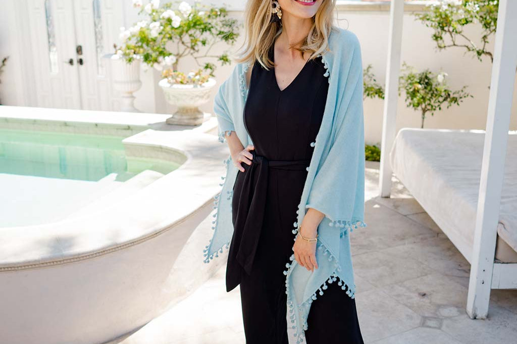 Model Wearing Alpine Cashmere Pom-Pom Triangle Wrap in Ice Blue