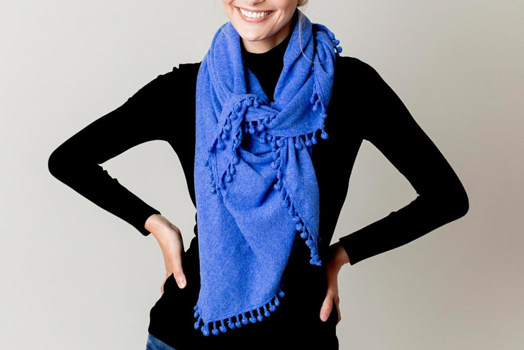 Model Wearing Alpine Cashmere Pom-Pom Triangle Wrap in Ocean Blue
