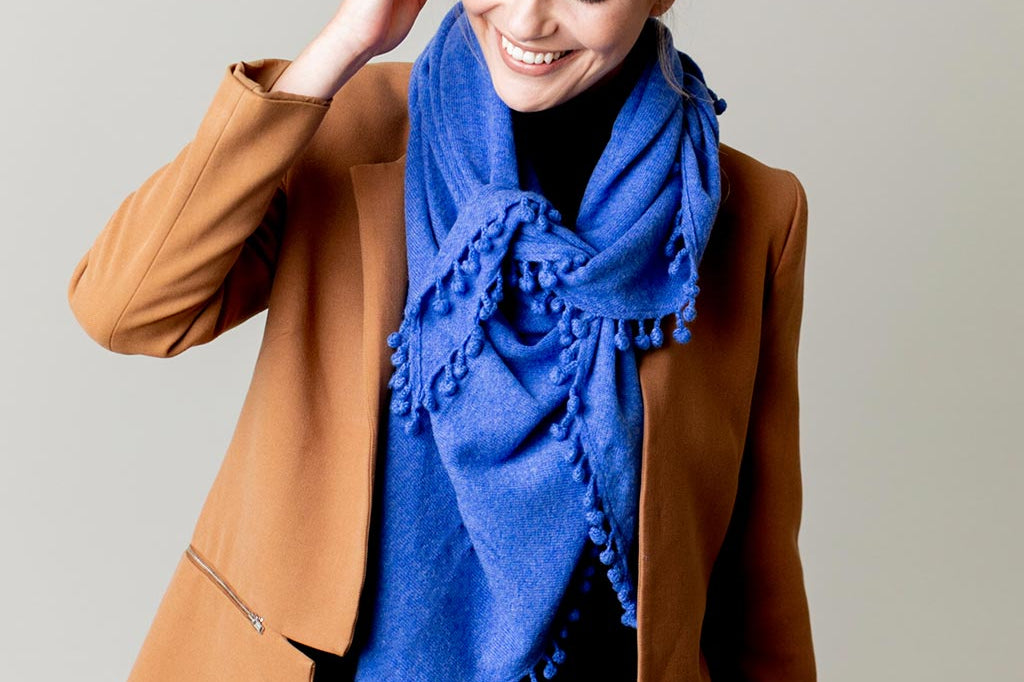 Model Wearing Alpine Cashmere Pom-Pom Triangle Wrap in Ocean Blue