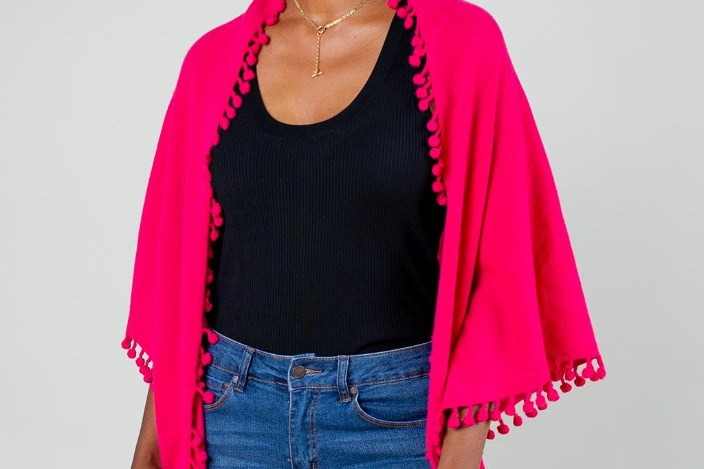 Model Wearing Alpine Cashmere Pom-Pom Triangle Wrap in Raspberry Pink