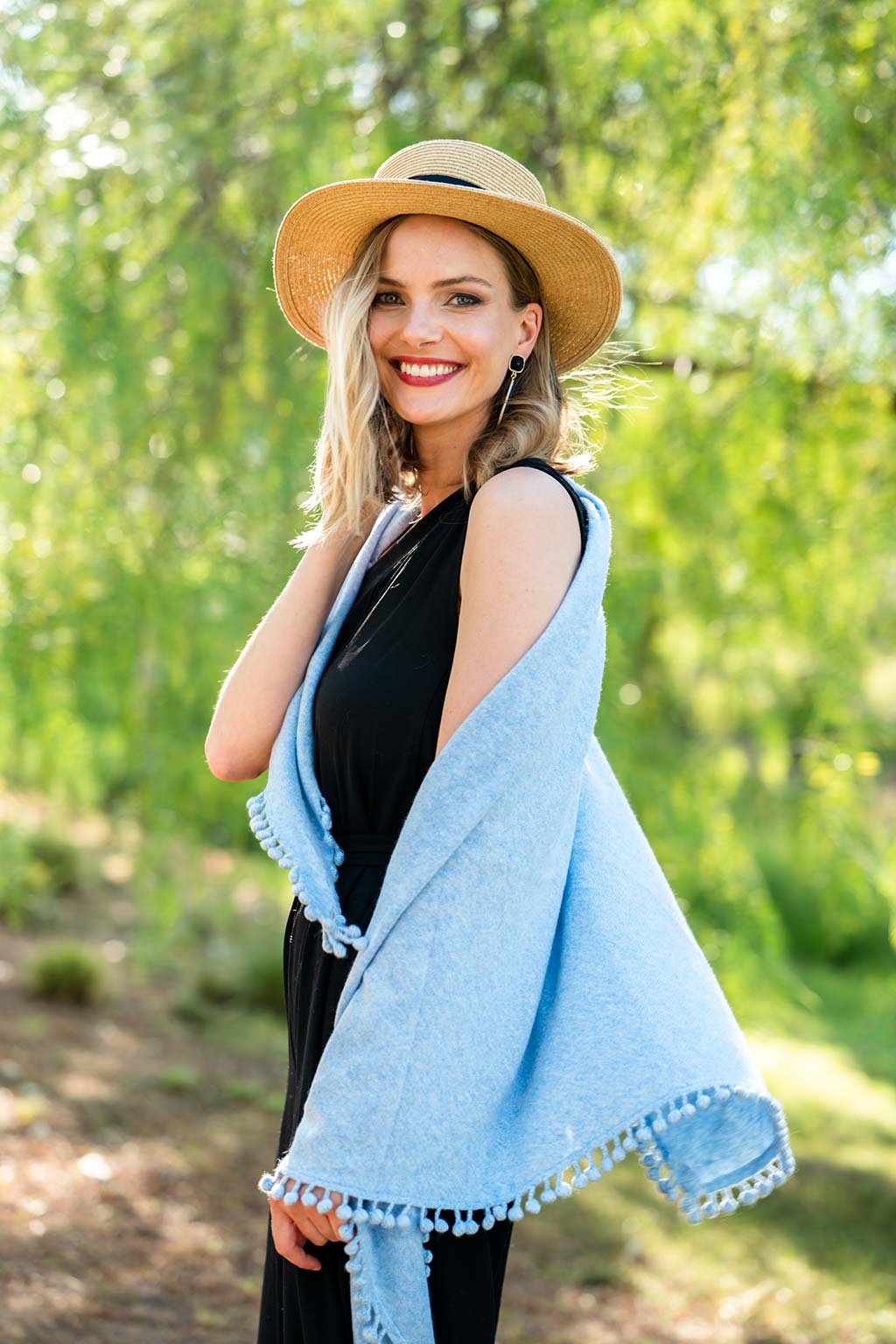Model Wearing Alpine Cashmere Pom-Pom Triangle Wrap in Sky Blue