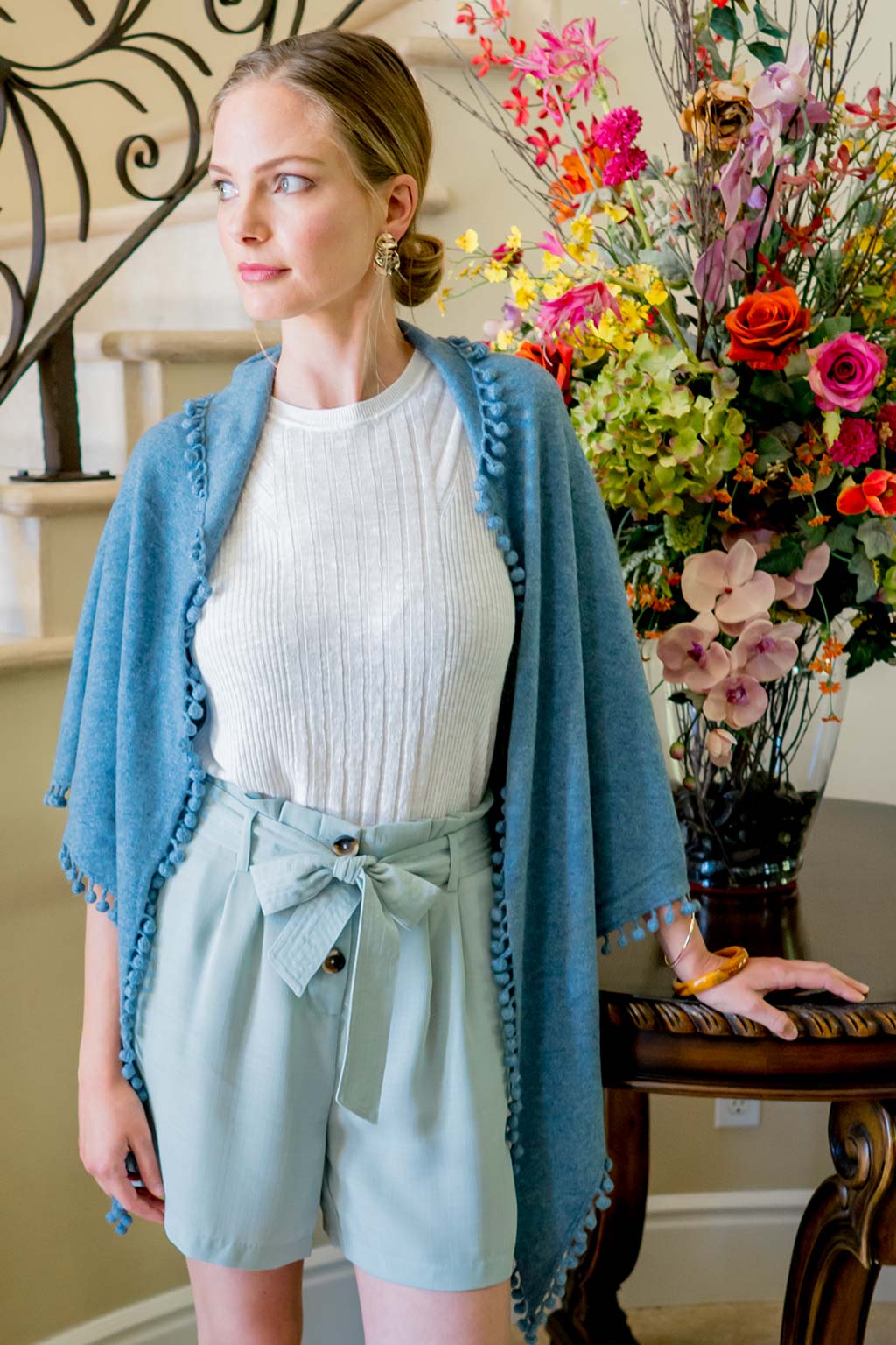 Model Wearing Alpine Cashmere Pom-Pom Triangle Wrap in Stonewash Blue