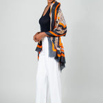 Model Wearing Alpine Cashmere Featherweight Printed Roma Scarf in Mandarin Orange